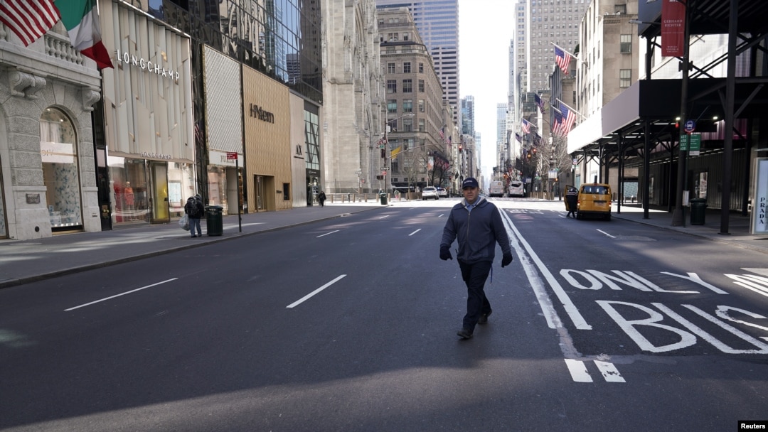 A lone man crosses 5th Ave following the outbreak of coronavirus disease (COVID-19), in the Manhattan borough of New York City, New York, U.S., March 24, 2020.
