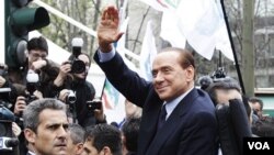 Perdana Menteri Italia, Silvio Berlusconi melambai saat meninggalkan kantor pengadilan di Milan.