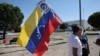 (FILE) A supporter holds a Venezuelan flag bearing a sign expressing against current Venezuela's President Nicolas Maduro in Madrid on September 8, 2024. 