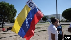 (FILE) A supporter holds a Venezuelan flag bearing a sign expressing against current Venezuela's President Nicolas Maduro in Madrid on September 8, 2024. 