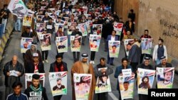 Para demonstran Irak dari Kota Nassiriya membawa poster orang-orang yang terbunuh dalam demo anti-pemerintah yang masih terus berlangsung di Baghdad, Irak, 6 Desember 2019. (Foto: Reuters)