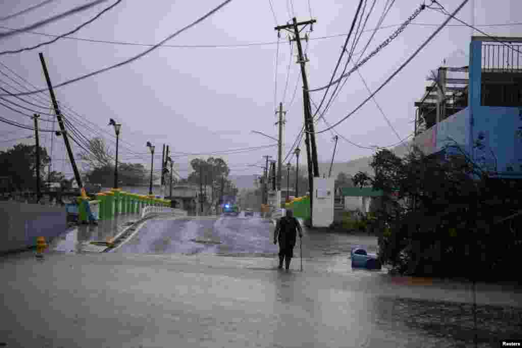 Un hombre camina por una calle inundada después de que el huracán Fiona afectara el área en Yauco, Puerto Rico, el 18 de septiembre de 2022. REUTERS/Ricardo Arduengo