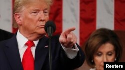 El presidente de EE.UU., Donald Trump, se dirige a los asistentes al congreso mientras que la presidenta de la Cámara de Representantes, Nancy Pelosi, baja la mirada durante el discurso del Estado de la Unión celebrado el 4 de febrero de 2020.