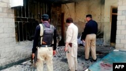 Pakistani security officials examine the site of a suicide bomb attack at the entrance of a hospital in Kotlan Saidan village on the outskirts of the northwestern city of Dera Ismail Khan on July 21, 2019. 