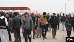 At a refugee camp outside Mosul, men gather to charge their phones, get their hair cut and tell tales of gruesome imprisonments for mundane crimes on Dec. 13, 2016 in Khazir, Iraq. (H.Murdock/VOA)