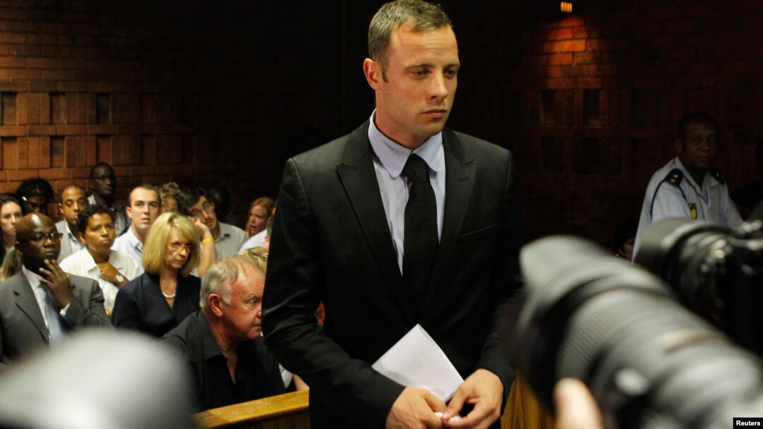 Oscar Pistorius stands in the dock during a break in court proceedings at the Pretoria Magistrates court, February 20, 2013.