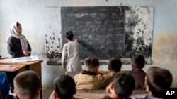 FILE - Afghan school boys attend their classroom on the first day of the new school year, in Kabul, March 25, 2023. The Taliban's "abusive" educational policies are harming boys as well as girls in Afghanistan, according to a Human Rights Watch report published Wednesday.