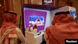 Participants watch on TV, as Saudi Crown Prince Mohammed bin Salman delivers a speech during the Future Investment Initiative Forum in Riyadh, Saudi Arabia, Oct. 24, 2018. 