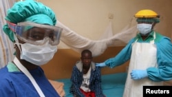 FILE - A Sierra Leonean nurse and doctor stand by a patient in a Lassa fever ward at Kenema Government Hospital in southeastern Sierra Leone, Feb. 7, 2011.