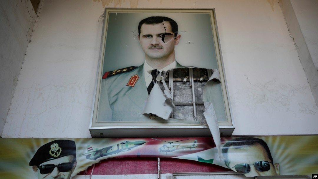 A torn poster shows ousted Syrian President Bashar al-Assad at the entrance of a detention center in Damascus, Syria, Dec. 14, 2024.