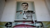 Một tấm áp phích rách nát có hình ảnh cố Tổng thống Syria Hafez al-Assad và con trai ông là Tổng thống bị lật đổ Bashar al-Assad, trên lối vào trại giam giữ an ninh khét tiếng có tên là Palestine Branch, tại Damascus, hôm 14/12/2024.