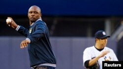 Patrick Vieira, left, head of the elite development squad at Manchester City Football Club, throws out the ceremonial first pitch near New York Yankees' Hiroki Kuroda, Yankee Stadium, New York, May 17, 2013.