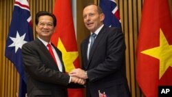 Vietnamese Prime Minister Nguyen Tan Dung and his Australian counterpart Tony Abbott shake hands before witnessing the signing of a "friendship agreement" between their countries at Parliament House in Canberra, Australia, March 18, 2015.