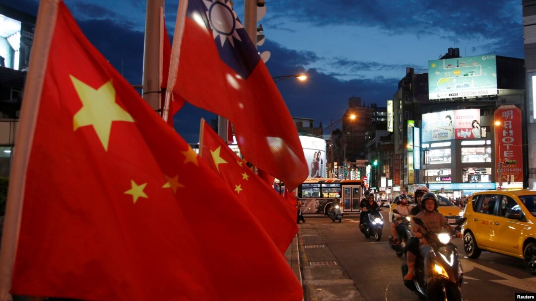 FILE - Flags of China and Taiwan flutter next to each other during a rally calling for peaceful reunification, days before the inauguration ceremony of President Tsai Ing-wen, in Taipei, Taiwan, May 14, 2016. 