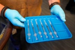 FILE - Syringes containing the COVID-19 vaccine are displayed in Pompano Beach, Fla., Jan. 6, 2021.