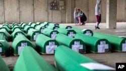 Para kerabat memeriksa peti-peti jenazah yang disiapkan untuk pemakaman di Potocari dekat Srebrenica, Bosnia, Rabu, 10 Juli 2019. 