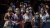 Para turis mengenakan masker menunggu untuk menyeberang jalan di Barcelona, Spanyol, 16 Juli 2020. 