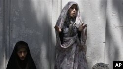 Iranian women pray outside Tehran University in Tehran, Iran, on Friday, July 27, 2012.