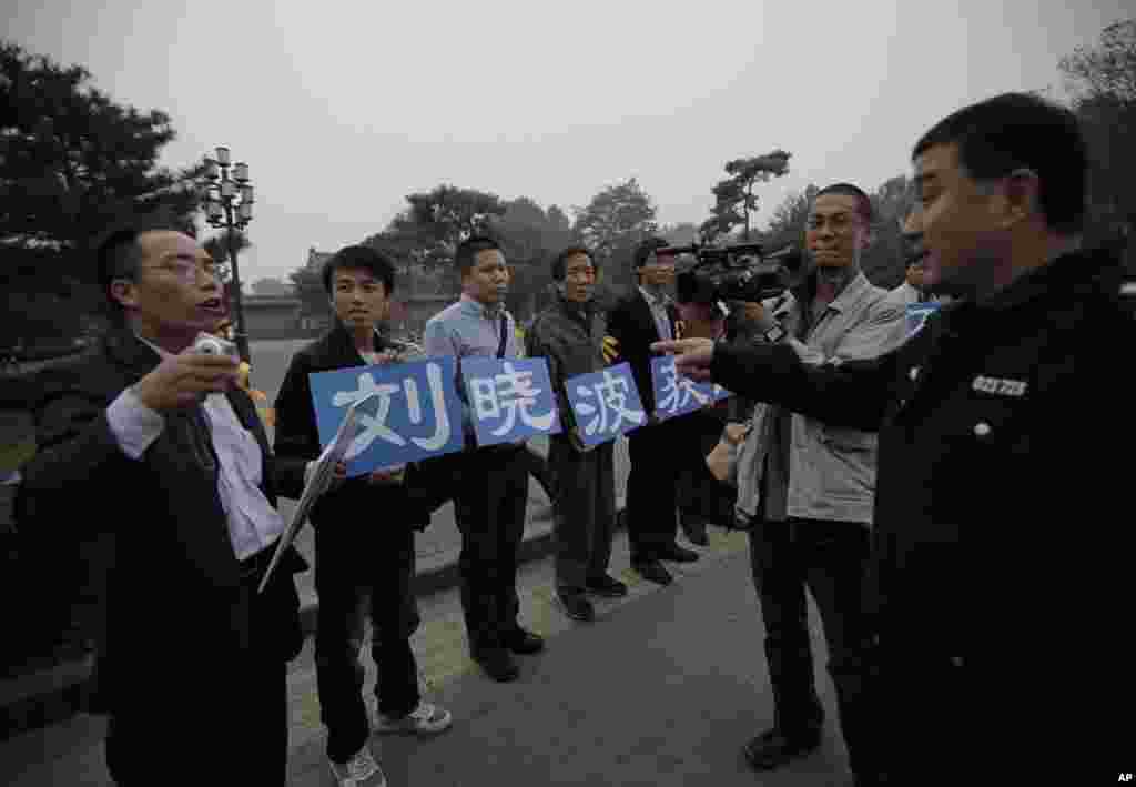 刘晓波的支持者在北京一个公园外面展示标语&ldquo;庆祝刘晓波获诺奖&rdquo;，警察和他们谈话（2010年10月8日）