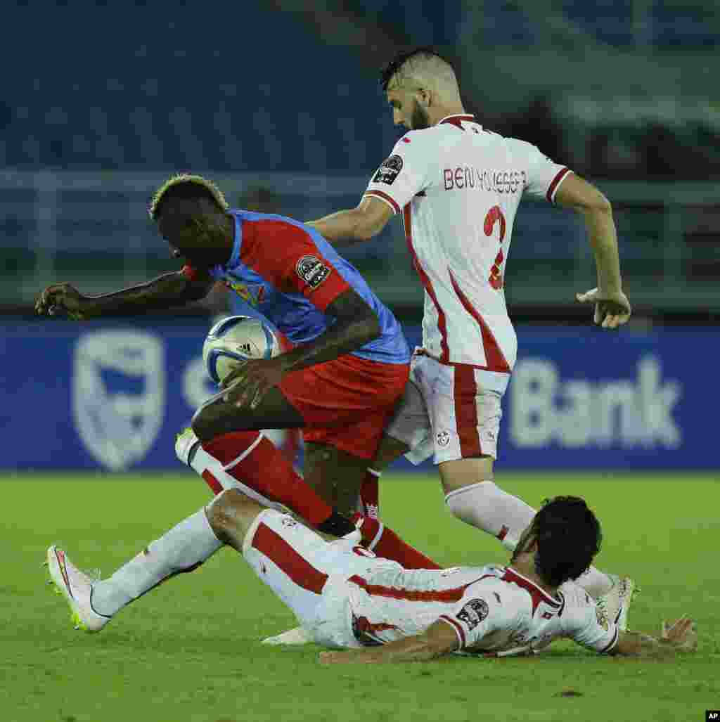 Loteteka Jeremy Bokila de la RD Congo, à gauche, est aux prises avec Mohamed Ali Yaacoubi de la Tunisie, couché, et Syam Youssef lors de leur match de football de la Coupe d&#39;Afrique des nations Groupe B à Bata, en Guinée équatoriale, lundi 26 janvier 2015.