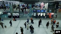 Para pelaju memasuki stasiun kereta Montparnasse di Paris, pada malam menjelang pemogokan nasional untuk memprotes rencana merombak sistem pensiun, 4 Desember 2019. (Foto: AFP)