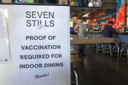 FILE - A proof of vaccination sign is posted at a bar in San Francisco, July 29, 2021.