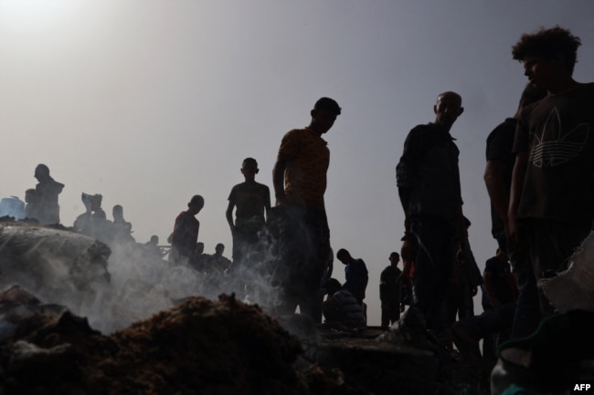 Warga Palestina berkumpul di lokasi serangan Israel di kamp pengungsi internal di Rafah pada 27 Mei 2024. (Foto: AFP)