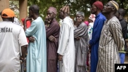 Voters wait in line outside a voting station in the fishing village of Ndayane on Nov. 17, 2024, during Senegal's parliamentary elections, with the country's new leaders aiming for a clear majority to see through their ambitious reform agenda.