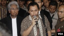 Gayus Tambunan memberikan keterangan kepada media, didampingi pengacaranya, Adnan Buyung Nasution, setelah menjalani sidang di pengadilan Jakarta Pusat, 19 Januari 2011.