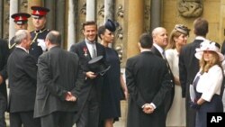 Soccer star David Beckham (C) and his wife Victoria arrive at Westminster Abbey before the wedding of Britain's Prince William and Kate Middleton, in central London April 29, 2011.