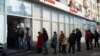 Des clients font la queue pour retirer de l'argent à un distributeur automatique d'Alfa Bank à Moscou, Russie, dimanche 27 février 2022.