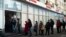 Des clients font la queue pour retirer de l'argent à un distributeur automatique d'Alfa Bank à Moscou, Russie, dimanche 27 février 2022.