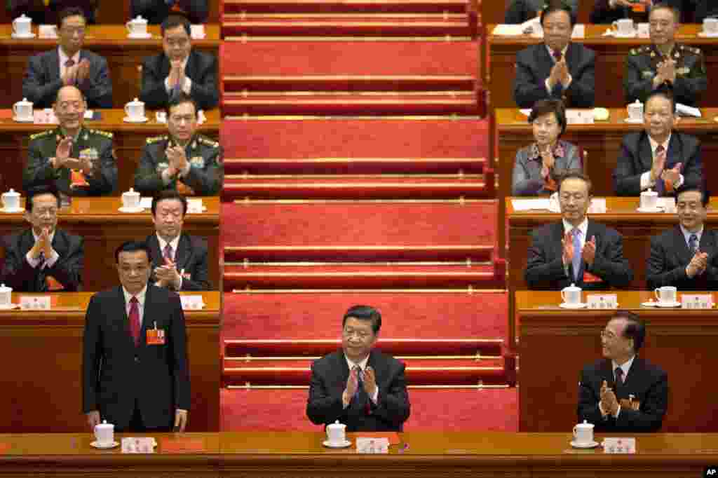 Li Keqiang stands up when he was announced to be China's new premier, while Chinese President Xi Jinping and former Chinese Premier Wen Jiabao clap at Beijing's Great Hall of the People, March 15, 2013.