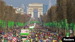 Les coureurs descendent l'avenue des Champs-Élysées au départ de la 40ème édition du marathon de Paris, France le 3 avril 2016.