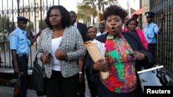 Kenyan members of parliament Gladys Wanga, left, and Christine Mbaya leave the National Assembly to protest against the approval of new anti-terrorism laws in Kenya's capital Nairobi, Dec. 18, 2014.