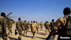 South Sudan army soldiers walk to board a military helicopter at Juba international airport, before heading to Bor, Dec. 25, 2013. 