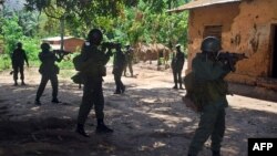 Des soldats de l'armée congolaise (FARDC) entourent une maison soupçonnée abriter un groupe de rebelles Mai Mai à Mboko, au Sud-Kivu, 10 novembre 2009.