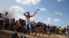Un manifestant palestinien jette des pierres aux soldats israéliens dans l’est de Gaza, le 9 octobre 2015