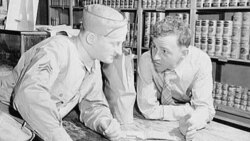 An American soldier at home on leave, learning about point rationing of food from his friend who runs the general store in Bowman, South Carolina, 1943.