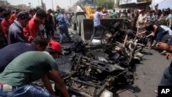 Civilians help a municipality bulldozer cleans up while citizens inspect the scene after a car bomb explosion at a crowded outdoor market in the Iraqi capital's eastern district of Sadr City, Iraq, May 11, 2016. 