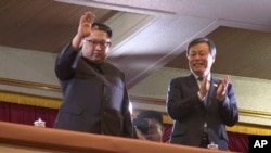 （2018年4月1日）北韓領導人金正恩（左）向平壤演出的一個南韓藝術團招手致意，率團的南韓文化體育觀光部長官都鍾煥在一旁鼓掌。
