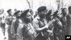 O líder da RENAMO, Afonso Dhlakama (centro, com mão na arma), algures em Moçambique, em foto de 1991