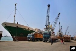 Cranes offload hay from a ship onto waiting trucks in the port of the northern city of Tripoli, Lebanon, Aug. 9, 2017.