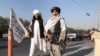 Pejuang Taliban memegang senapan serbu M16 berdiri di luar gedung Kementerian Dalam Negeri di Kabul, Afghanistan, 16 Agustus 2021. (REUTERS/Stringer/File Photo)