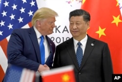 FILE - In this June 29, 2019, file photo, U.S. President Donald Trump, left, shakes hands with Chinese President Xi Jinping during a meeting on the sidelines of the G-20 summit in Osaka,