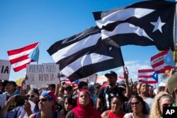 Description: Demonstrators march against governor Ricardo Rosello, in San Juan, Puerto Rico, Wednesday, July 17, 2019.