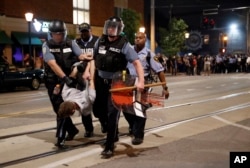 Police arrest a man as they try to clear a violent crowd, Sept. 16, 2017, in University City, Mo. Earlier, protesters marched peacefully in response to a not guilty verdict in the trial of former St. Louis police officer Jason Stockley.