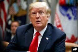 President Donald Trump listens to a reporter's question during a meeting of the President's National Council of the American Worker in the Roosevelt Room of the White House, Sept. 17, 2018, in Washington.