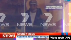 FILE - This image taken from video shows a man believed to be a gunman inside a cafe in Sydney, Australia, Dec. 15, 2014. 