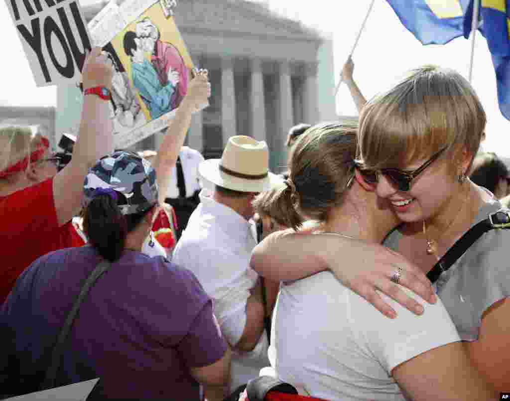 26일 미 연방대법원이 캘리포니아주 동성 결혼 금지법을 위헌으로 발표하자, 미국 워싱턴 DC 아메리칸대학교 학생 몰리 와그너(오른쪽)와 샤론 버크가 대법원의 결정에 환호하며 껴안고 있다.